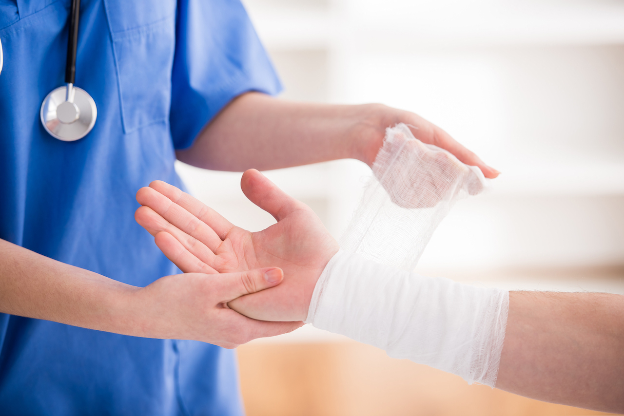 nurse bandaging a person's arm